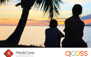Silhouette of woman and boy sitting down by a sunset.