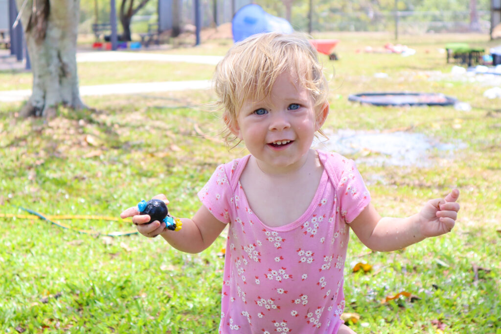toddler smiling while playing outside